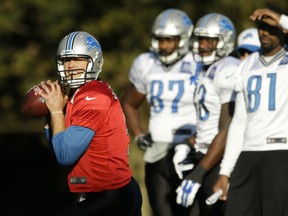 Detroit Lions quarterback Matthew Stafford, left, takes part in a training session as wide receiver Calvin Johnson stands in the background, right, at the Grove Hotel in Chandler's Cross, England, Wednesday, Oct. 28, 2015.  The Detroit Lions are due to play the Kansas City Chiefs at Wembley stadium in London on Sunday in a regular season NFL game.  (AP Photo/Matt Dunham)