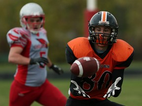 F. J. Brennan's Landon Porter watches ƒcole secondaire l'Essor's Ryan Prieur make a catch before he is tackled at F. J. Brennan Catholic High School in Windsor on Friday, October 30, 2015.                                       (TYLER BROWNBRIDGE/The Windsor Star)