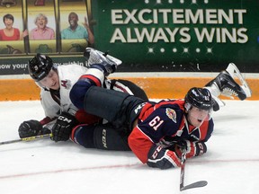 Luke Boka runs over Guelph Storm defence man Kyle Rhodes during the Windsor Spitfires' 2-1 win at the Sleeman Centre Friday, Oct. 16, 2015. Tony Saxon, Mercury staff