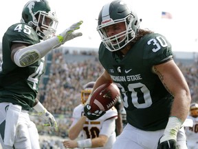 Michigan State linebackers Riley Bullough (30) and Darien Harris (45) celebrate Bullough's fumble recovery and return against Central Michigan during the fourth quarter of an NCAA college football game, Saturday, Sept. 26, 2015, in East Lansing, Mich. Michigan State won 30-10. (AP Photo/Al Goldis)