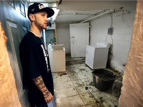 Dustin Gerner is shown on Wednesday, Oct. 21, 2015, at the apartment building he lives in at 444 Park Street in Windsor, Ont. Tenants are upset with the rundown condition of the building. He is shown in the basement laundry room that is flooded and mouldy.