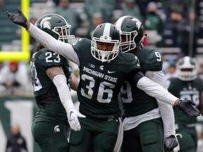 Windsor's Arjen Colquhoun (36), Chris Frey (23) and Montae Nicholson celebrate a play during the fourth quarter of an NCAA college football game against Purdue, Saturday, Oct. 3, 2015, in East Lansing, Mich. Michigan State won 24-21. (AP Photo/Al Goldis)