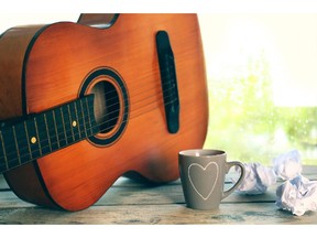 Acoustic guitar and cup of tea next to window with rain drops. Photo by fotolia.com.