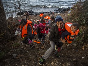 Syrian refugees climb up to a field after arriving from Turkey at the Greek island of Lesbos on an overcrowded dinghy, Tuesday, Oct. 27, 2015. Greece’s government says it is preparing a rent-assistance program to cope with a growing number of refugees, who face the oncoming winter and mounting resistance in Europe.