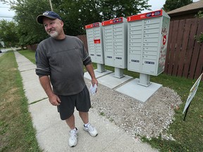 Rick Fortin grabs his mail from one of the new mail boxes in Tecumseh in this 2015 file photo.