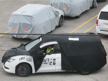 Blanketed minivans are shown at the Fiat Chrysler Automotive's Windsor Assembly Plant on Tuesday, Oct. 6, 2015.