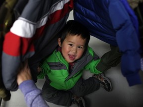 Barry, 2, (last name not given) plays hide and seek in a rack of winter jackets at Coats for Kids at the Unemployed Help Centre, Saturday, Nov. 2, 2013. (DAX MELMER/ The Windsor Star)
