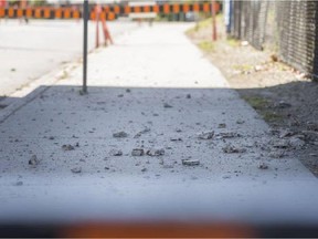 Debris is seen on the sidewalk on Wyandotte Street West under the Ambassador Bridge on Saturday, Oct. 10, 2015. The City of Windsor closed the street after chunks of concrete was scattered all over the road.