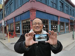 Henry Tam, a Toronto-area businessman, is shown on Tuesday, Oct. 13, 2015, in downtown Windsor, Ont., where he has purchased a number of properties on Chatham Street. He displays a conceptual drawing on his cell phone of the improvements he has envisioned for the building.
