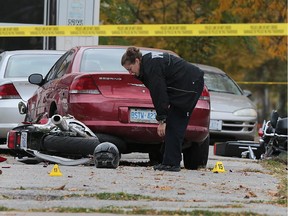 A Windsor police officer investigates the scene of a fatal motorcycle accident on Wednesday, Oct. 14, 2015, on Sandwich St. just west of the Ambassador Bridge.