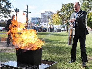 Windsor mayor Drew Dilkens puts out a fire with an extinguisher during a media conference for the kick-off of fire prevention week on Monday, Oct. 5, 2015 at the City Hall. The Windsor Fire and Rescue Service was on hand with the controlled training exercise to teach people how to safely use an extinguisher.   (DAN JANISSE/The Windsor Star)