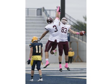 McMaster's Mitch O'Connor, centre, and Danny Vandervoort jump for high five after a touchdown as Windsor's Spencer Trinier looks on as the Windsor Lancers host the McMaster Marauders during OUA football action at Alumni Field, Saturday, Oct. 3, 2015.  (DAX MELMER/The Windsor Star)