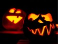 Three pumpkins carved as grimacing faces and having candles inside glow in the dark on Oct. 28, 2014 in Hanover, central Germany, days before Halloween.