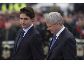 Prime Minister Stephen Harper and prime minister designate Justin Trudeau walk together during a ceremony marking the one year anniversary of the attack on Parliament hill Thursday Oct. 22, 2015 at the National War Memorial in Ottawa.