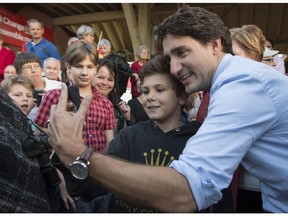 Liberal leader Justin Trudeau takes a photo with a young boy during a rally Wednesday, October 7, 2015 in Sussex, New Brunswick.