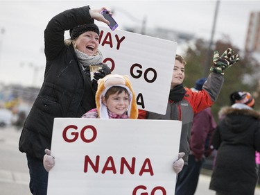 Jack, 10, and Molly Fraser, 7, left, are joined by their mother, Kelly Fraser as they cheer on their nana, Judy Lawlor who was running the 38th Detroit Free Press/Talmer Bank Marathon in downtown Windsor, Sunday, Oct. 18, 2015.