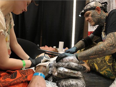 Brent McCowan, a tatau artist from Villach, Austria, applies the ancient-style of tattoo by tapping a wooden stick into the arm of Don Foxx, 48, of Kokomo, Ind. during the Motor City Tattoo Expo in Detroit, Mich. on Saturday, March 7, 2015.