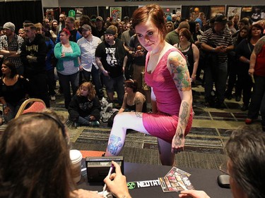 Judges look at a leg tattoo during the Motor City Tattoo Expo in Detroit, Mich. on Saturday, March 7, 2015.