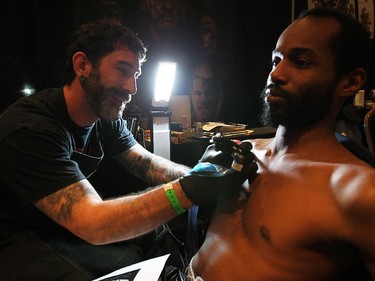 Mike Taylor gets a chess tattoo from North Carolina artist Gabe Sandy during the Motor City Tattoo Expo in Detroit, Mich. on Saturday, March 7, 2015.