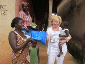 Rotarian Kim Spirou hands out mosquito nets in Ghana in this handout photo.