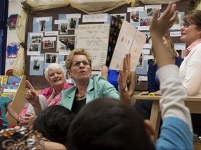 Ontario Premier and Liberal Leader Kathleen Wynne (right) sits with Education Minsiter Liz Sandals as she reads to a full day kindergarten class at Westwood Public School in Guelph, Ont. in this 2014 file photo.