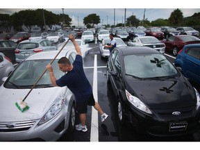 File photo of Edgardo Costanzo washing new cars on the sales lot of a Ford AutoNation car dealership on Sept. 4, 2013 in North Miami, Florida.