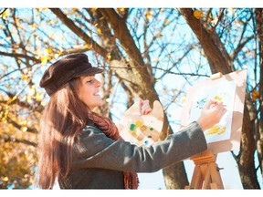 Portrait of a young woman painting outdoors. (Fotolia.com)