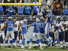 Detroit Lions place holder Sam Martin (6) celebrates the game winning field goal kicked by Matt Prater in the overtime period to defeat the Chicago Bears in an NFL football game, Sunday, Oct. 18, 2015, in Detroit.