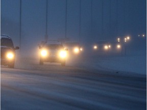 Vehicles travel westbound on E.C. Row Expressway near Howard Avenue trudge through heavy snowfall.