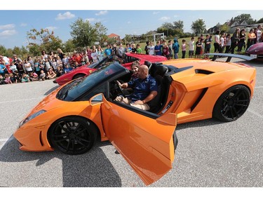 A handful of lucky students at St. Joseph elementary school in River Canard had a chance to get a ride in some high-priced sports cars on Wednesday, Oct. 7, 2015. A canned food drive was held at the school. For every 10 cans brought in the student received a ticket for a chance to ride in one of the cars. Student Natalie DiPasquale gets set to go for a ride with Rob Osman in his 2009 Lamborghini.  (DAN JANISSE/The Windsor Star)