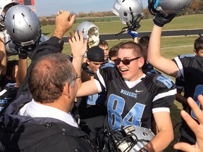 The Villanova Wildcats football team raise their helmets to salute Cody Ajersch who scored the final touchdown of the high school football game against Tecumseh Vista on October 23, 2015.  Ajersch, a student with special needs and team manager for four years suited up with the Catholic High School football team and played.   Both teams erupted in applause after the run for the TD.