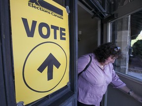 A woman walks out of the Willistead Coach House after voting at an advanced polling station for the upcoming Federal election, Saturday, Oct. 10, 2015.
