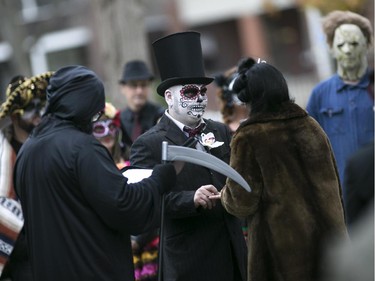 Bride and groom, Kasandra Kehoe and Craig Price, centre, tie the knot with friends and family at Windsor Grove Cemetery while wearing costumes for Halloween, Saturday, Oct. 31, 2015.