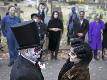 Bride and groom, Kasandra Kehoe and Craig Price, left, tie the knot with friends and family at Windsor Grove Cemetery while wearing costumes for Halloween, Saturday, Oct. 31, 2015.