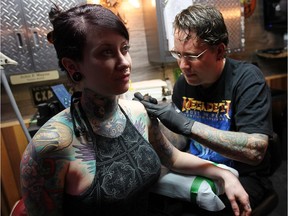 Tattoo artist John Wayne, owner of Beesting Tattoo in Belle River, Ont. works on a piece for Athena Vegh.