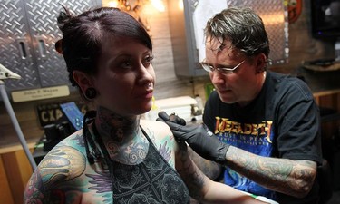 Tattoo artist John Wayne, owner of Beesting Tattoo in Belle River, ON. works on a piece for Athena Vegh.