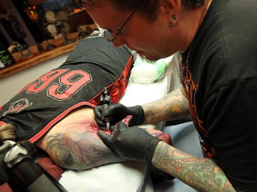 Tattoo artist John Wayne works on the arm of Scott Robinson at his studio in Belle River on Wednesday, March 4, 2015.        (TYLER BROWNBRIDGE/The Windsor Star) Windsor Ink