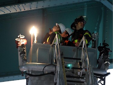 Inspectors from Transport Canada are joined by firefighters, city officials and engineers from the Ambassador Bridge as they inspect the underside of the 85-year-old bridge in Windsor on Thursday, October 15, 2015. Falling concrete forced the closure of the roads beneath the bridge.