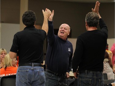 Tracey Ramsey supporters Roland Kiehne, Gord Gray and Chris Taylor (left to right) celebrate after it was announced she defeated incumbent Jeff Watson in Essex on Monday, October 19, 2015.
