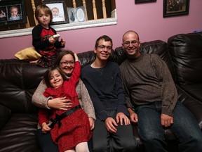 The Bondy family Hailey, left, Amy, Shane, and Mike, and Noah, top, share a moment at their LaSalle home on Oct. 2, 2015.