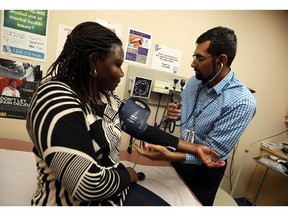 Dr. Mohammed Hussain sees patient Jean Moro at City Centre Health Care in Windsor on Tuesday, October 6, 2015. The clinic is housed in the CMHA office but operates as a normal clinic.                                     (TYLER BROWNBRIDGE/The Windsor Star)