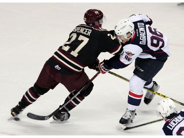 The Windsor Spitfires Cristiano DiGiacinto fires the puck while being checked by the Peterborough Petes Matthew Spencer at the WFCU Centre in Windsor on Thursday, October 8, 2015.                                      (TYLER BROWNBRIDGE/The Windsor Star)