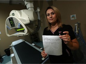 Amy Grady holds a copy of the petition she is circulating at ESR Clinics in Windsor on Tuesday, September 29, 2015. Grady is hoping to speed up the process of receiving an MRI.
