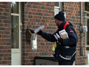 In this file photo, Shannon Allard of Canada Post delivers mail to a doorstep on Thompson Avenue in Riverside Wednesday Dec. 11, 2013. (NICK BRANCACCIO/The Windsor Star)