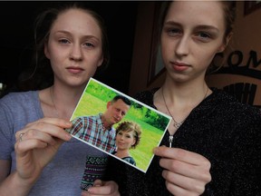 Windsor, Ontario. October 14, 2015 - Payton Desbiens, 18, left, and her sister Madison Desbiens, 16, hold a photograph of their parents, Kerri and Rich Desbiens, who both died within weeks of each other.  To make matters worse, heartless thieves took many of their possessions, including family heirlooms and photographs.  (NICK BRANCACCIO/The Windsor Star)  NOT for daily photo gallery.