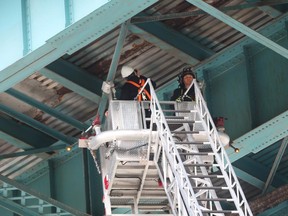 Windsor Fire Service assists a consultant engineer during a close inspection of the Ambassador Bridge near Huron Church road in Windsor, Ontario on October 14, 2015.