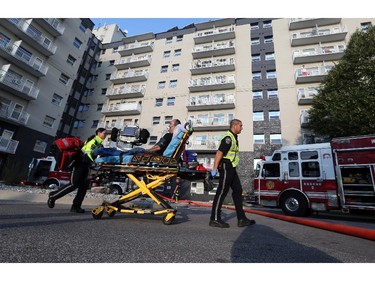 A patient is transported to an ambulance by EMS paramedics at the scene of an early morning apartment fire at 2455 Rivard in Windsor, Ontario on October 7, 2015.   (JASON KRYK/The Windsor Star)