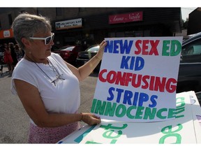 Windsor, Ontario. September 2, 2015 -  Jeannie Cowan selects a placard during a demonstration against the new sex education curriculum at office of MPP Lisa Gretzky on Tecumseh Road East, Wednesday September 2, 2015.  (NICK BRANCACCIO/The Windsor Star)