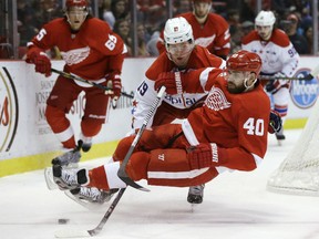 Detroit Red Wings left wing Henrik Zetterberg (40) of Sweden is tripped by Washington Capitals center Nicklas Backstrom (19), of Sweden, during the first period of an NHL hockey game in Detroit, Friday, Jan. 31, 2014. (AP Photo/Carlos Osorio)