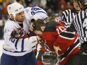 Toronto Maple Leafs' Tie Domi (left) punches New Jersey Devils' Jay Pandolfo in a fight during second period NHL action in Toronto Saturday, March 30, 2002. Domi is stickhandling another role away from the ice: author. Simon & Schuster Canada announced on Tuesday that it will publish Domi's forthcoming memoir. THE CANADIAN PRESS/Kevin Frayer